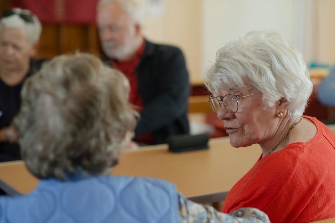 Older women are conversing at a table.